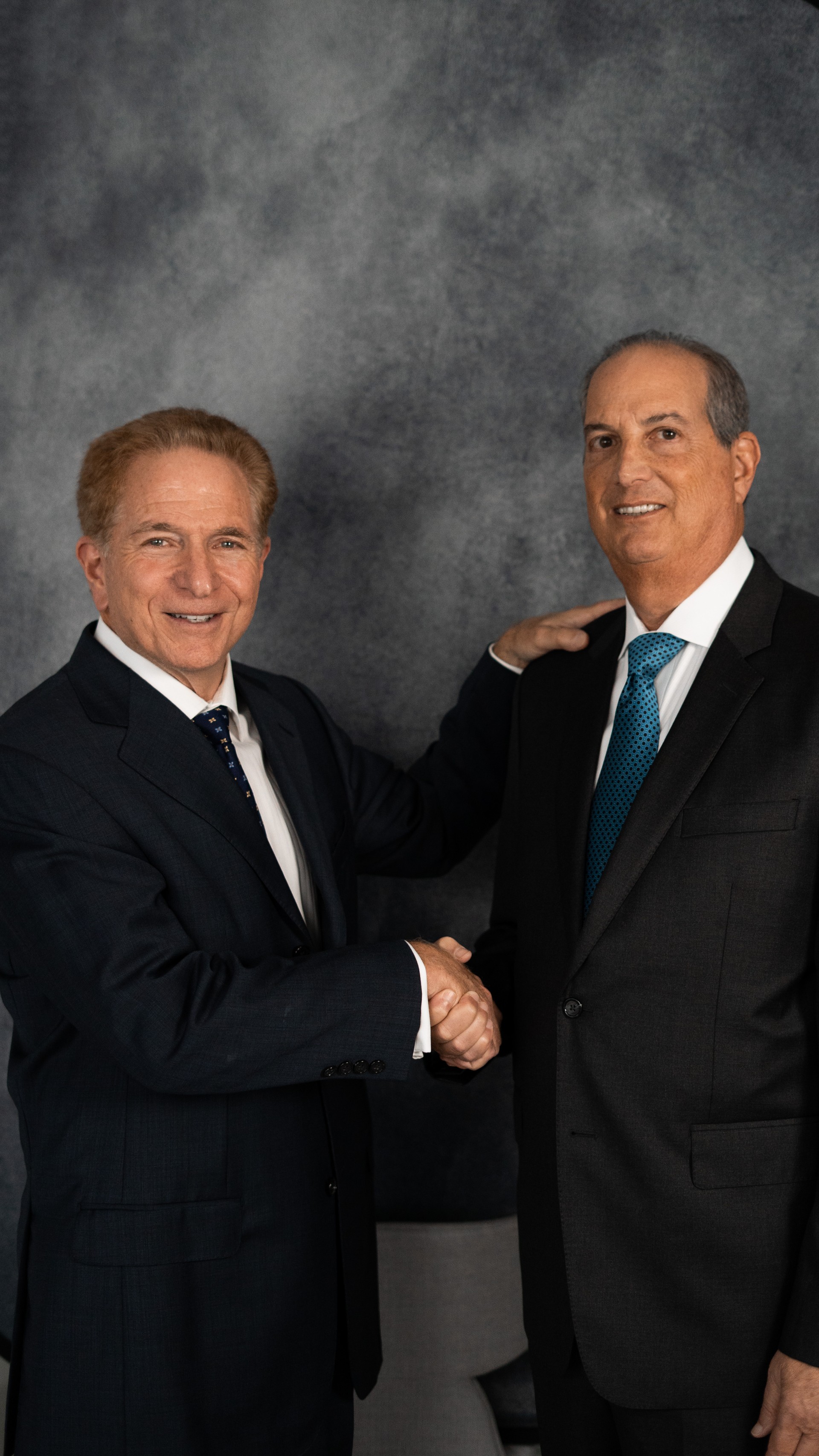 Two partners of Katzman, Wasserman, Bennardini & Rubinstein shaking hands